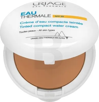 A compact makeup product with the lid open, showing the tinted cream inside.