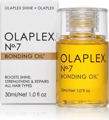 A bottle of Olaplex No. 7 Bonding Oil next to its packaging.