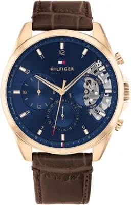A close-up studio shot of a Tommy Hilfiger men's watch with a blue dial and a brown leather strap.