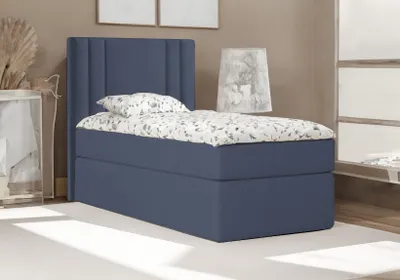 A dark blue bed with a patterned duvet and pillow is shown in a room setting.