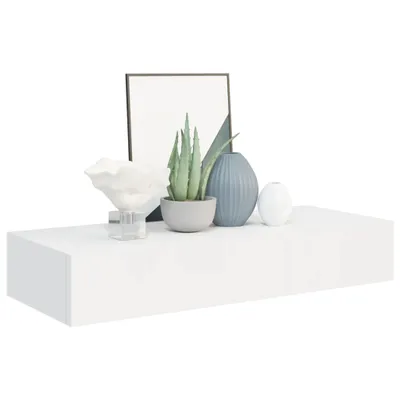 A white floating shelf with decorative items on it.