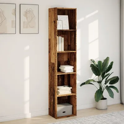 A tall, narrow bookshelf with a rustic wood finish stands against a white wall. There are several books and decorative items on the shelves. A large potted plant is to the right of the bookshelf.