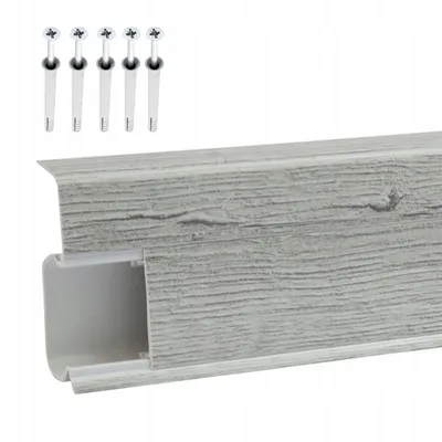 A close-up view of a gray wood-grain patterned PVC skirting board with a white interior channel, along with five screws and wall plugs.