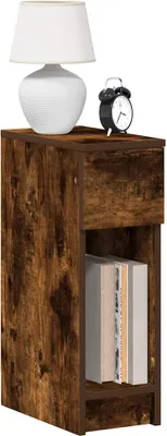 A bedside table with a drawer and an open shelf, displaying a lamp and an alarm clock on top, and books on the shelf.