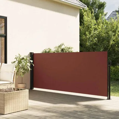 A retractable side awning on a wooden deck next to a house.