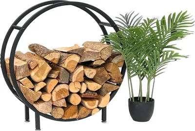 A black metal firewood rack filled with logs, next to a potted green plant.