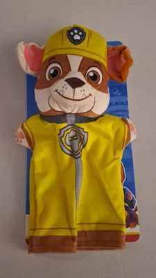A stuffed toy dog wearing a yellow uniform and helmet, presented on a blue backing card.