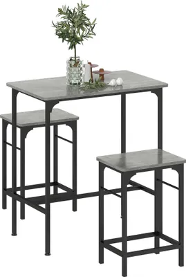 A gray and black bar table set with two stools, with a small plant and decorative items on the table.