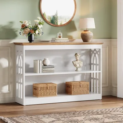A console table with decorative items on it, placed in a room with a mirror and a lamp.