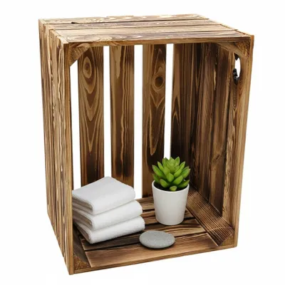 A wooden crate with folded towels, a potted plant, and a stone.