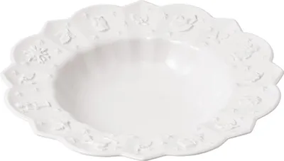 A white ceramic bowl with a scalloped edge and embossed festive designs.