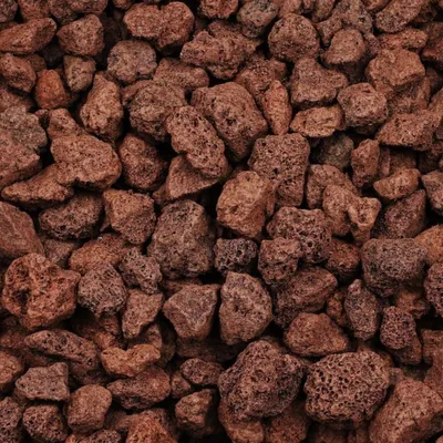 A close-up, overhead view of a pile of red-brown lava stones.
