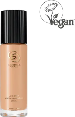 A bottle of foundation with a black cap and gold branding, next to a vegan logo.