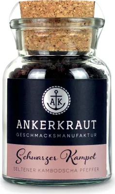 A glass jar filled with black peppercorns, sealed with a cork and featuring a label.