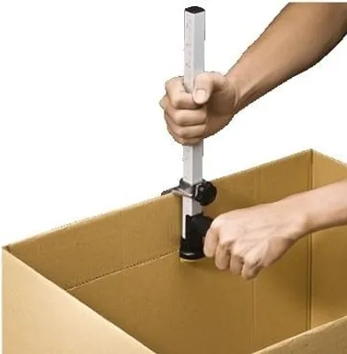 A person is using a tool to adjust the height of a cardboard box.