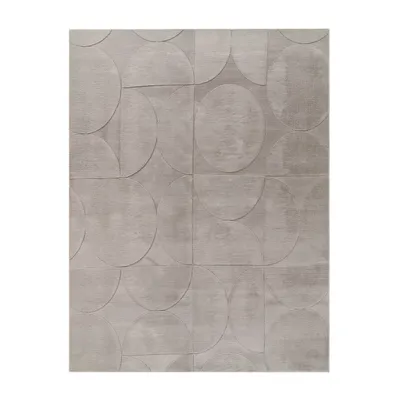 A flat lay of a grey rug with a geometric pattern of circles and semi-circles.