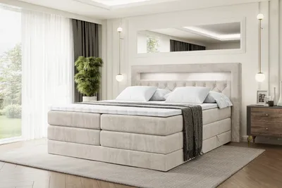A bedroom scene featuring a large bed with a headboard and LED lighting, a nightstand, and a large window with curtains.
