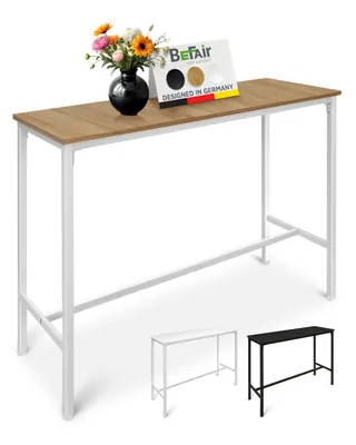A tall, narrow table with a wooden top and white metal legs, decorated with a vase of flowers and a small display card. Two smaller versions of the table, one white and one black, are shown in the foreground.