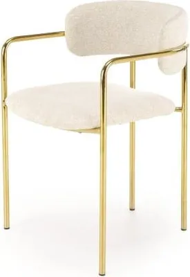 A studio shot of a beige armchair with gold metal legs.