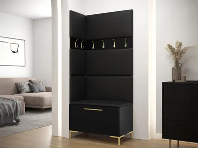 A modern entryway with a black corner coat rack and bench with gold accents, next to a black dresser with a vase of dried flowers.