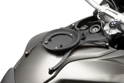 A close-up of a motorcycle's fuel tank with a mounting bracket attached.