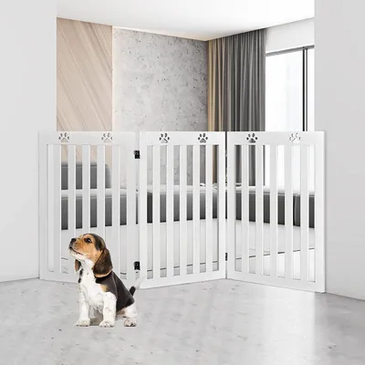 A white wooden pet gate with paw print accents is set up in a modern living room, with a beagle puppy sitting in front of it.