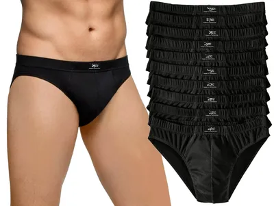 A man wearing black briefs, with a stack of black briefs to the right.