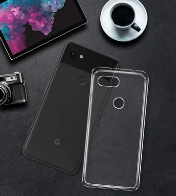 A flat lay of a Google Pixel 3a XL phone, a clear phone case, a tablet, and a cup of coffee on a dark textured surface.