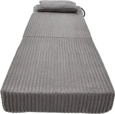 A folded-up grey mattress with a pillow on top, against a white background.