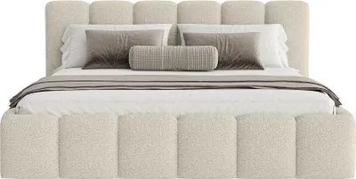 A beige upholstered bed with pillows and a throw blanket.