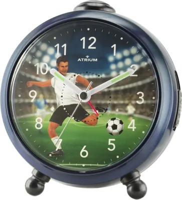 An alarm clock with a football theme, showing a player kicking a ball on a stadium background.
