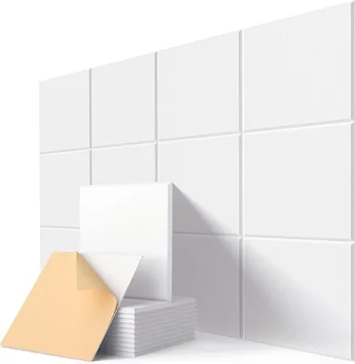 A stack of white acoustic panels with one panel peeled back to show adhesive backing, arranged in front of a wall of installed acoustic panels.