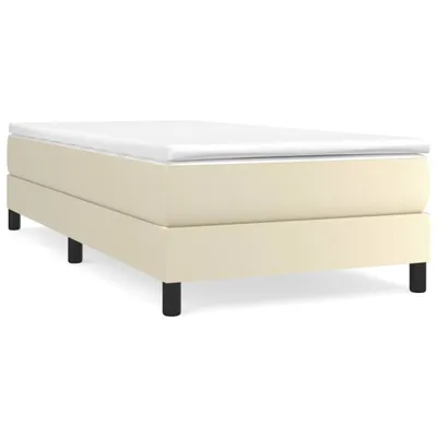 A cream-colored box spring bed frame with a white mattress topper on a white background.