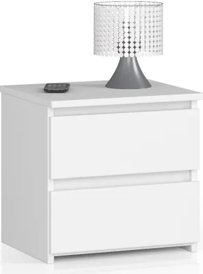 A white nightstand with two drawers, topped with a modern lamp and a remote control.