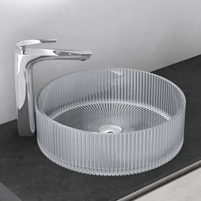 A clear, professional shot of a glass sink and faucet on a countertop.