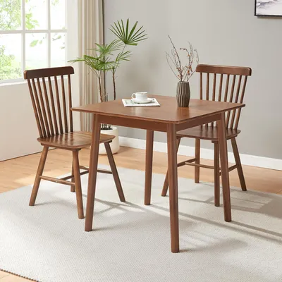 A wooden dining table with two chairs in a room with a window and plants.