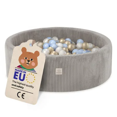 A grey corduroy ball pit filled with blue, white, and gold balls, with a product tag attached.