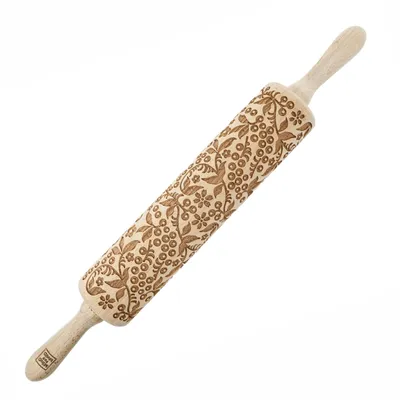 A wooden rolling pin with an engraved floral and berry pattern.