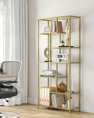 A gold metal bookshelf with various decorative items and books.