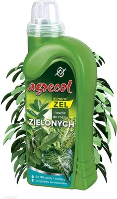 A green bottle of liquid fertilizer with a label showing plant leaves, surrounded by green leaves.