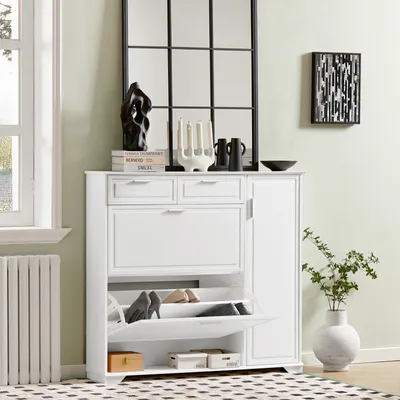 A white shoe cabinet with multiple storage compartments is shown in a room setting, next to a window and a radiator.