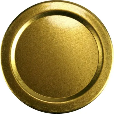 A close-up, top-down view of a single gold-colored metal lid for a jar.