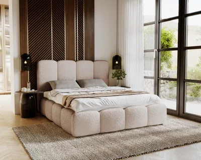A bedroom scene featuring a large bed with a textured headboard and base, set against a decorative wooden wall panel and large windows with a view of greenery.