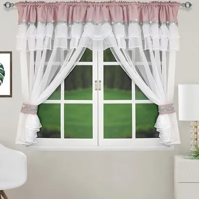 A window with curtains and a view of green grass outside.