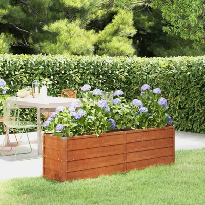 A garden scene with a wooden planter box filled with purple hydrangeas, a table and chairs in the background.