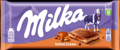 A Milka Toffee Creme chocolate bar wrapper with images of mountains, a cow, and a piece of chocolate.