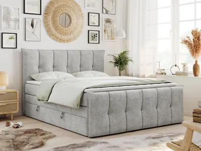 A bedroom scene with a king-size bed as the focal point, decorated with artwork and plants.