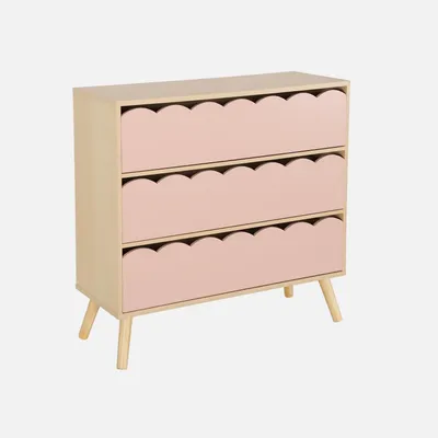 A light wood dresser with three pink drawers, each with a scalloped edge, on a light gray background.