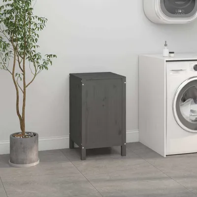 A dark gray wooden cabinet is placed next to a washing machine in a laundry room.