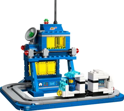 A LEGO set depicting a space-themed control center with a small vehicle on a track.